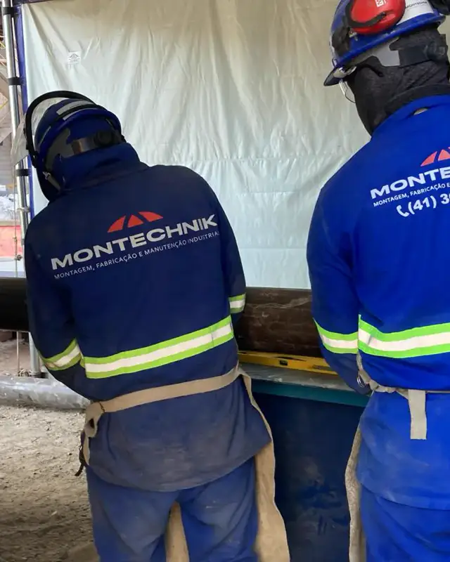 Dois colaboradores com o uniforme da Montechnik em campo